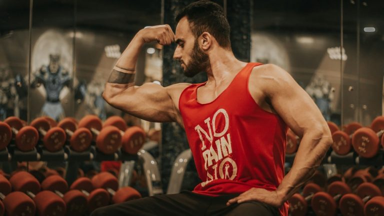 man in red tank top sitting on chair